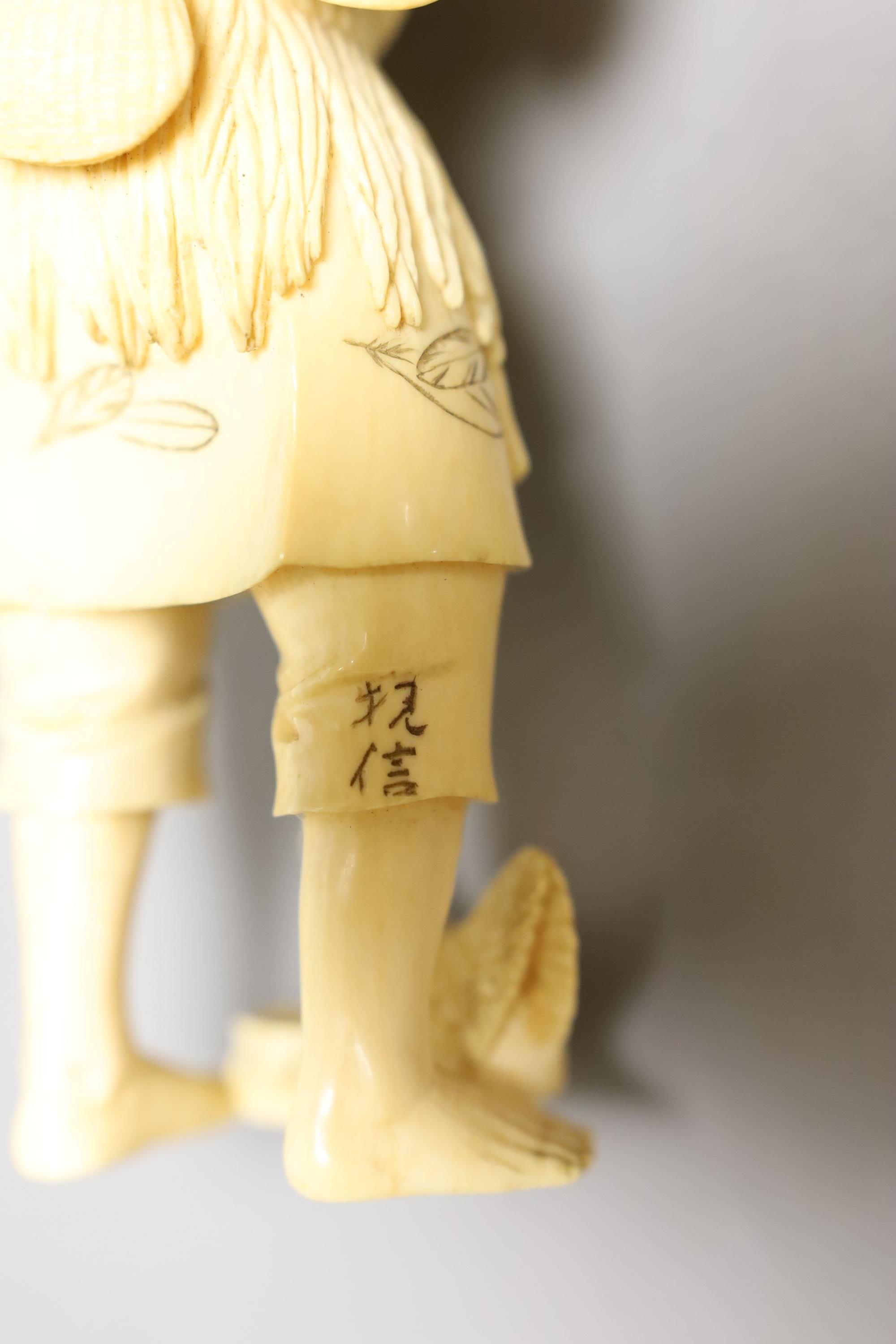 A Japanese ivory okimono of a fisherman and a chicken, Meiji period, signed, 15cm tall